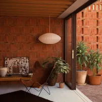 Ambiente residencial com plantas e acabamento em tijolos aparentes
